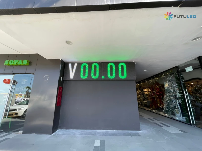 Pizarra LED de tipo de cambio con dígitos verdes instalada en el exterior de una plaza comercial por Futuled