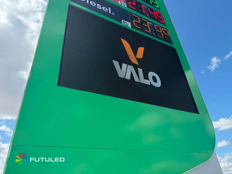 Tótem digital verde de gasolinera con pantalla LED mostrando el logotipo de VALO y precios de combustible, fabricado por Futuled.